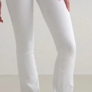 Vita ribbade leggings från Aim'n - Säljer ett par vita ribbade leggings från Aim'n i storlek M. De har en snygg, tight passform och är tillverkade i mjukt och stretchigt material med 92% polyamid och 8% elastan. Perfekta för dig som gillar stilrena och bekväma byxor.