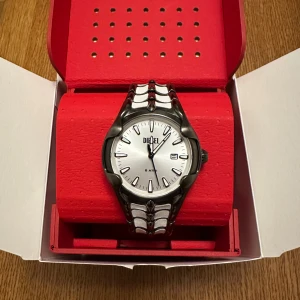 Diesel Vert Limited Edition  - Säljer en Diesel Vert Limited Edition klocka, nr 135 av 300. Klockan har en rund silverfärgad urtavla med svart index och datumvisning. Armbandet är i rostfritt stål med unikt mönster i silver och svart. Snygg och modern design, perfekt för dig som gillar statement-accessoarer.