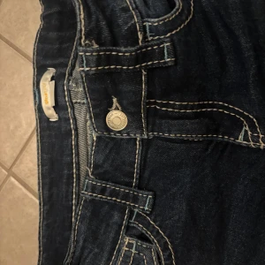 bootcut jeans - snygga blå low bootcut jeans från Gina. Jeansen har vit sömn som är svinsnygg!! tror ej de säljs längre! +liten defekt sista bilden fast har haft de sen ja beställde dem.🥹🫰🏼skriv för frågor!