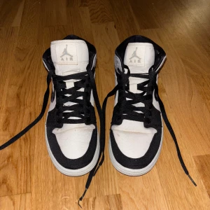 Nike Air Jordan 1 svart/vit - Nike Air Jordan 1 sneakers i svart och vit med klassisk high-top siluett. Materialet är en mix av syntet och textil och har inte försökt tvätta dom men fläckar går att ta bort. Användes några gånger och kommer inte längre till användning💕