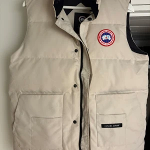 Beige dunväst från Canada Goose - Beige dunväst från Canada Goose. Nästan oanvänd! Står storlek Medium men den är snarare S/M, alltså en mindre Medium.