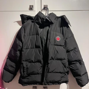 Trapstar jacka med röd text - Svart trapstar jacka med röd text, sitter bra och är väldigt skön på vintern, dock så har den två små skador, en vid ärmen och en vid kragen, båda är på insidan så det syns inte.