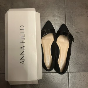 Svarta ballerinaskor  - Jätte fina svarta ballerinaskor från Anna Field med spetsig tå och ett spänne framtill. Skorna passar perfekt  till jeans eller kjol. Använda 2 gånger men säljer då de tyvärr är för små för mig. Det står storlek 38 men skulle säga att det är en 37. Vill även nämna att det finns en risk för skavsår men det kan nog bero på att de var för små på mig💕
