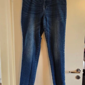 Blå jeans från Newport Bay, storlek 32 - Snygga blå jeans från Newport Bay Sailing Club i klassisk straight fit. Jeansen har fem fickor, tydliga slitningar och kontrastsömmar. Passar dig som gillar en tidlös look med lite vintage-vibe. Materialet är robust denim och midjan är normal. Knappt använda, fint skick. 