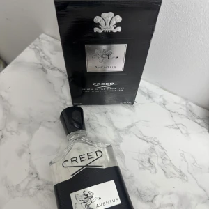 Creed Aventus 100ml EdP - Creed Aventus är en ikonisk parfym med exklusiv känsla. Flaskan rymmer 100 ml och är perfekt för dig som vill sticka ut. Tillverkad av noggrant utvalda essenser och naturliga infusioner. Skapad av parfymhuset Creed i Paris.