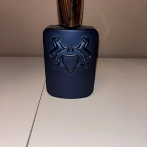  Parfums de Marly layton 125 ml - Exklusiv parfym från Parfums de Marly. Perfekt för dig som vill sticka ut med en lyxig och modern doft. Snygg flaska med ikonisk design – ett måste i samlingen! Detta är den 125 ml flaskan. 