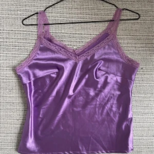 Lila satin-linne med spets - Lila satin-linne med spets. Aldrig använt. Passar S-M