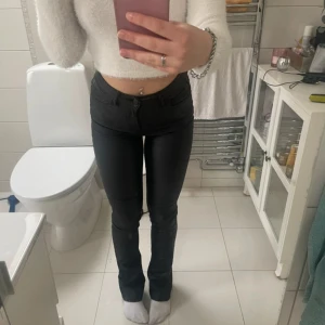 Svarta utsvängda jeans från Perfect Jeans - Snygga svarta utsvängda jeans från Perfect Jeans i storlek 32. De har hög midja. Materialet är stretchigt och har en lätt glansig finish som ger en cool look. Passar dig som gillar en tight och figurnära stil. Lite skador på bakfickorna men inget man tänker på .