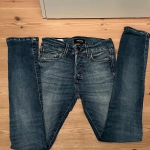 Slim Glenn jeans från Jack & Jones - Snygga blå jeans från Jack & Jones i modellen Slim Glenn. Jeansen har en slim passform, snygga slitningar framtill. Materialet är mjukt jeans och färgen är mörkblå med ljusare tvätt. Perfekt för dig som gillar en slim siluett. Hör av er vid minsta fråga! (priset är ej ristat i sten) mvh Victor!