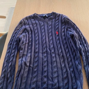 Marinblå kabelstickad tröja Polo Ralph Lauren - Säljer denna kabel stickade Ralph lauren tröjan. Storlek S. Har haft ett litet hål på sidan som har sytts ihop. 