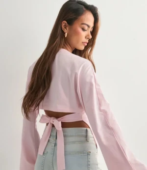 Ljusrosa topp med knyt - Trendig ljusrosa topp med långa ärmar och snygg knytning i ryggen. Aldrig använd och har prislapp kvar, skriv för fler bilder, slutsåld 