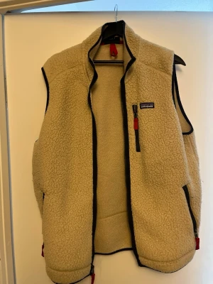 fleeceväst från Patagonia - beige fleeceväst från Patagonia med svarta detaljer och dragkedjor. Bara att höra av er om ni undrar något.