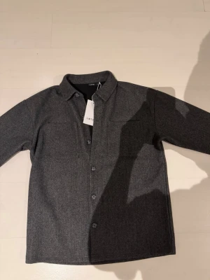 LMTD Overshirt - Säljer nu denna schyssta grå overshirt som alldrig är använd pga för stor för mig! Denna overshirten kan passa bra in nu till våren då den inte är så varm. Overshirten har storleken 158/164 eller för 13 till 14 åringar men kan även passa äldre eller längre!
