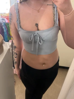 Ljusblå croppad linnetopp med knyt - Snygg ljusblå croppad linnetopp med smala axelband och söt knytning framtill. 