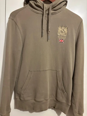 Olivgrön hoodie från Morris - Olivgrön tröja från Morris i fint skick. Klassisk modell som passar till det mesta. Använd fåtal gånger, inga fläckar eller hål. Det Står storlek XS men skulle säga mer åt S hållet!