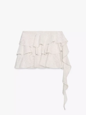 Glittrig volangkjol med knytband - Superfin kort kjol i glittrigt silvertyg med flera volanger och ett långt knytband på sidan. Perfekt för dig som vill ha något extra till outfiten. Passar bra på festival men även till alla sommarfester!!💖🤩🤩 Nyskick!!