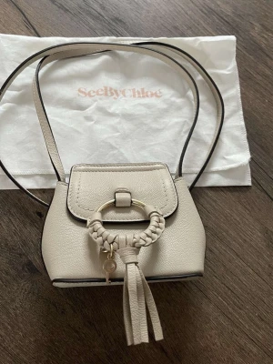 See by Chloe Joan Mini,mini bag. - See by Chloe Joan Mini,mini bag. Den minsta varianten.  Material: Läder. Färg: Beige, Crèmefärgad. Väska: 8×14cm.  Väskan är i fint skick och följer med tillhörande förvaring påse till.
