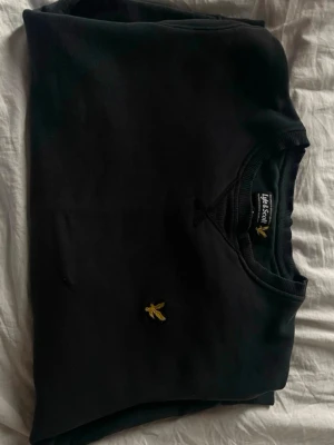 ***Svart sweatshirt från Lyle & Scott*** - Klassisk svart sweatshirt från Lyle & Scott med rund halsringning och den ikoniska gula örnloggan broderad på bröstet. 