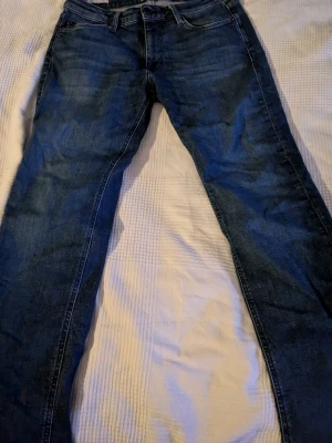 Blå jeans Jack & Jones Clark 30/32 - Säljer ett par klassiska blå jeans från Jack & Jones i modellen Clark. Jeansen har fem fickor, normal passform och raka ben. Tillverkade i slitstarkt denimtyg med snygg tvättad look och kontrastsömmar. Perfekta till vardagslooken. Kan diskutera pris