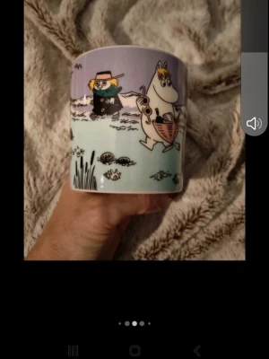 Muminmugg Snorkfröken Arabia - Säljer en muminmugg från Arabia med motiv av Snorkfröken och Snusmumriken. Muggen har lila och ljusblå bakgrund med tecknade figurer från Muminvärlden. Tillverkad i porslin och har ett bekvämt handtag. Perfekt för dig som samlar på Muminmuggar eller gillar söta motiv. Nypris 329 kr och muggen är helt ny:)