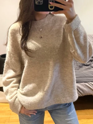 Beige stickad tröja H&M - Säljer denna stickade tröja från HM. Storlek S, oversized i modellen så passar M också. Använd men i fint skick. Har några defekter i form av ett litet hål vid ena armen och lite smuts i ullen som man kan se på bilderna. Är lite nopprig. Samt har små fläckar av smink på lappen och vid kragen. 280 kr + frakt! Vid fler frågor, etc skriv privat 🙌🏼🩷☀️🏄🏽‍♀️🌄