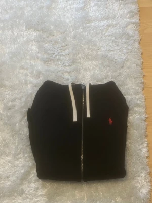 Ralph lauren svart zip hoodie - Hej säljer denna Ralph lauren zipper. Som är äkta och köpt i johnells. Storlek S. Helt nytt skick. Fråga om bilder så skickas det