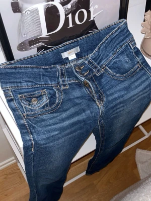 Blå bootcut jeans med kontrastsömmar💗 - Säljer ett par blå jeans med bootcut-modell och snygga kontrastsömmar. Klassisk femficksdesign och dragkedja framtill. Jeansen är jätte snygga och sitter otroligt tyvärr för små för mig de har bara vanliga fickor där bak inga knappar elle nåt💗💗