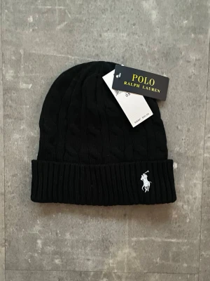Svart kabelstickad mössa Polo Ralph Lauren - Helt Ny Ralph Lauren mössa (Svart)                                           Kom gärna med bud!