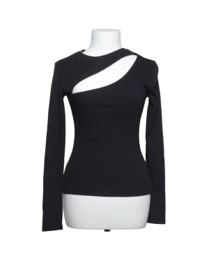 Svart långärmad topp med cut-out - Trendig svart långärmad topp med unik cut-out detalj över bröstet. Figurnära passform och rund halsringning. Perfekt för dig som vill sticka ut med en edgy och modern stil.🥰
