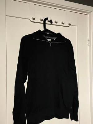 Svart stickad tröja Jack & Jones - Snygg svart stickad tröja från Jack & Jones med halv dragkedja vid halsen. 