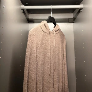 Brun merino ull hoodie från scalpers - En fin merino tröja med luva. Tillverkad i ett merino och är fluffigt material som ger en avslappnad och trendig look. Perfekt för lager-på-lager och chill dagar.