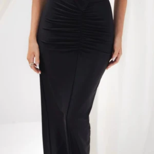 Svart långkjol med rynkade detaljer - Säljer en svart långkjol från Oh Polly med snygga rynkade detaljer framtill. Kjolen har en tight passform och är gjord i mjukt, stretchigt syntetmaterial som sitter skönt mot kroppen. Perfekt för dig som gillar en stilren och trendig look.