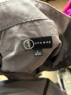 Grå skjorta från Oneway, storlek L - Säljer en enkel och stilren grå skjorta från Oneway i storlek L. Skjortan har klassisk krage, lång ärm och knappar framtill. Perfekt för dig som gillar en clean och avslappnad look.