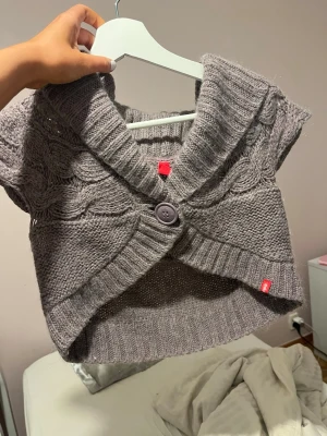 Lila stickad kofta  XS - Kort lila stickad kofta från Gap i storlek XS. Koftan har ett grovt kabelstickat mönster, bred krage och stängs med en stor knapp framtill. Perfekt att slänga över en topp för extra värme och stil.