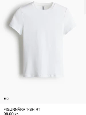 Vit figurnära t-shirt - Klassisk vit t-shirt i figurnära passform med rund hals och korta ärmar. Tillverkad i mjuk bomull som känns skön mot huden. Perfekt basplagg att matcha med allt i garderoben.