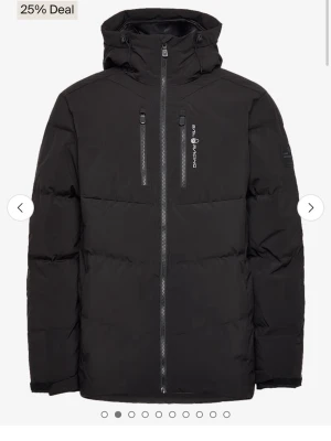 Sail Racing patrol down jacket - Snygg svart dunjacka från Sail Racing med två bröstfickor med dragkedja, hög krage och fast huva. Jackan har raka ärmar, diskret logga på bröstet och patch på ärmen. Perfekt för kalla dagar och har en modern, stilren look. För lat för att ta bilder, men den är i princip nyskick och knappast använd.