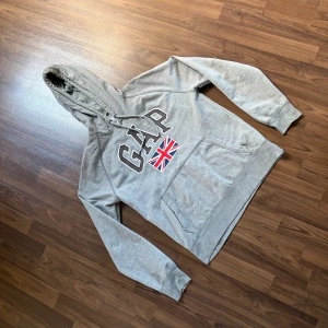 Gap hoodie  - Tja! Säljer en tvär fet gap hoodie med UK flagga. Otroligt fet design och passar till allt. Väldigt liten defekt på känguru fickan (se sid 4,5) men syns ej vid användning. Hör av dig om du har någon fundering!