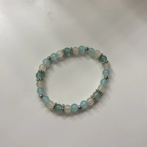 Handgjort Pärlarmband i blått och vitt - Stilrent armband med runda pärlor i ljusblått och vitt, varvat med små silvriga detaljer. Elastisk tråd gör det enkelt att ta på och av. Perfekt accessoar för att ge din look en fräsch touch.  Finns flera färger att välja på så bara att höra av sig vid frågor❤️ armband görs efter önskemål