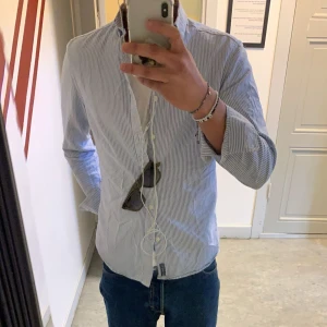 Randig skjorta II East West - Randig skjorta från East West | Storlek: S - Skicket pa skjortan är  bra - pris: 300kr - Modellen är 180cm och väger 65kg