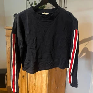 Blå tröja med revärer  - Marinblå röja med röda och vita revärer i stolen 158/164