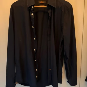 Morris Oxford skjorta  - Säljer en mörkblå Oxfordskjorta från Morris i storlek L. Sparsamt andvänd, inga defekter. Säljer eftersom att jag har växt ur den. Nypris är uppemot 1200. Hör gärna av dig vid funderingar 🤩