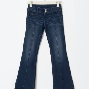 SLUTSÅLDA mörkblå bootcut jeans från Gina Tricot - Supersnygga slutsålda mörkblå Pleated flare jeans från Gina Tricot med bootcut och låg midja. Snygga framfickor och markerade sömmar längs benen.