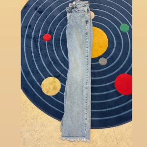 Ljusblå raka jeans med rå kant - Säljer ett par ljusblå jeans med rak passform och hög midja. Jeansen har klassisk femficksdesign och rå, fransig kant längst ner vid bensluten för en trendig look. Perfekta till sneakers eller boots.frpn Gina tricot 