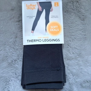Svarta thermo leggings från Softer Days - Mörkgrå svarta thermo leggings från Softer Days i storlek L/XL. De har en mjuk, borstad insida som håller dig varm och är tillverkade i stretchigt material med 95% polyester och 5% elastan. Perfekta för kalla dagar när du vill ha det extra bekvämt.