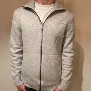 Ljusgrå kofta med dragkedja - Snygg ljusgrå kofta från Massimo Dutti i en blandning av ull och kashmir. Nypris 3500 pris kan diskuteras vid snabba köp. Jätte bra skick utan några defekter lite liten i storlek.