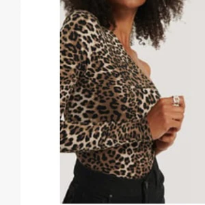 Stretchig one shoulder leopardmönstrad topp med puffärm! - Trendig topp i stretchig material och leopardmönster med puffärm och asymmetrisk design!    Axelbredd 35 Längth 54