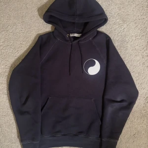 our legacy hoodie  - Svart hoodie från Our Legacy med vit grafisk detalj på bröstet och stor WORK SHOP-tryck på ryggen. Klassisk känguruficka, snörning i huvan och mjukt material. Perfekt för dig som gillar streetwear och stilrena plagg. storlek 48 motsvarar då medium ish 