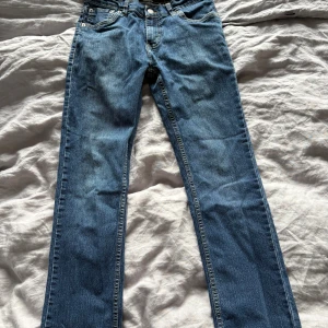 Levi's 511 Slim  jeans - Snygga Levi's 511 Slim jeans i klassisk blå denim. Modellen har raka ben, fem fickor och tydliga kontrastsömmar. Ikonisk röd Levi's-tag på bakfickan och bekväm passform med normal midja. Perfekta för en avslappnad och stilren look.