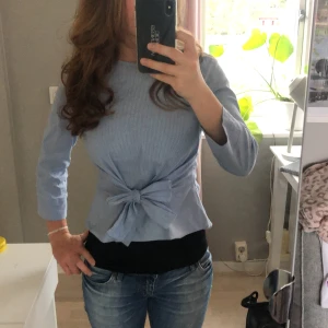 Blus med rosett - Säljer en ljusblå blus med rosett på framsidan och trekvartsärmar. Hör av dig vid minsta minsta lilla fråga🥰