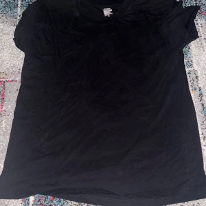 Svart Casa Blanca t-shirt med tryck - Svart t-shirt från Casa Blanca med ett stort blått grafiskt tryck och texten 'CASA BLANCA' på framsidan. Klassisk rund hals och korta ärmar. Tillverkad i mjuk bomull för en skön känsla.